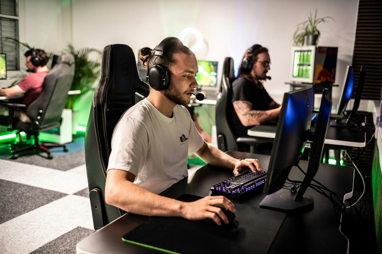 A man sitting at a computer with headphones on