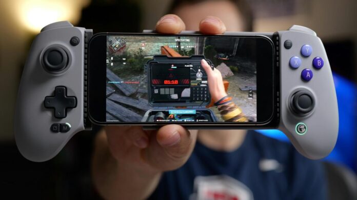 Person holding smartphone with game controller attachment