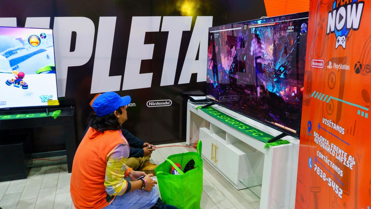 Two people playing video games on a large screen